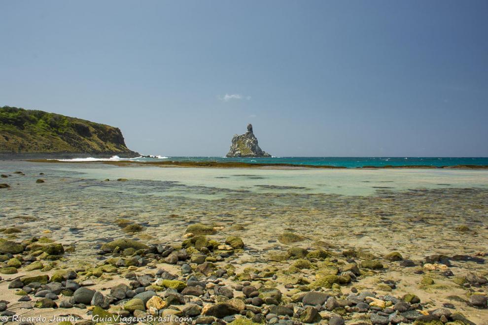 Imagem das pequenas pedras e da piscina natural da Praia do Atalaia.